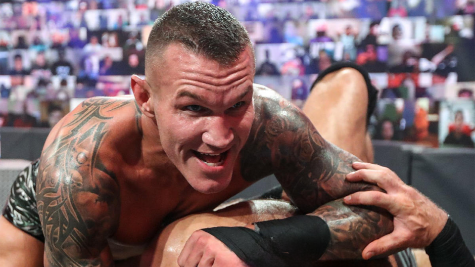 Randy Orton holding down Drew McIntyre on the announce table at WWE SummerSlam 2020